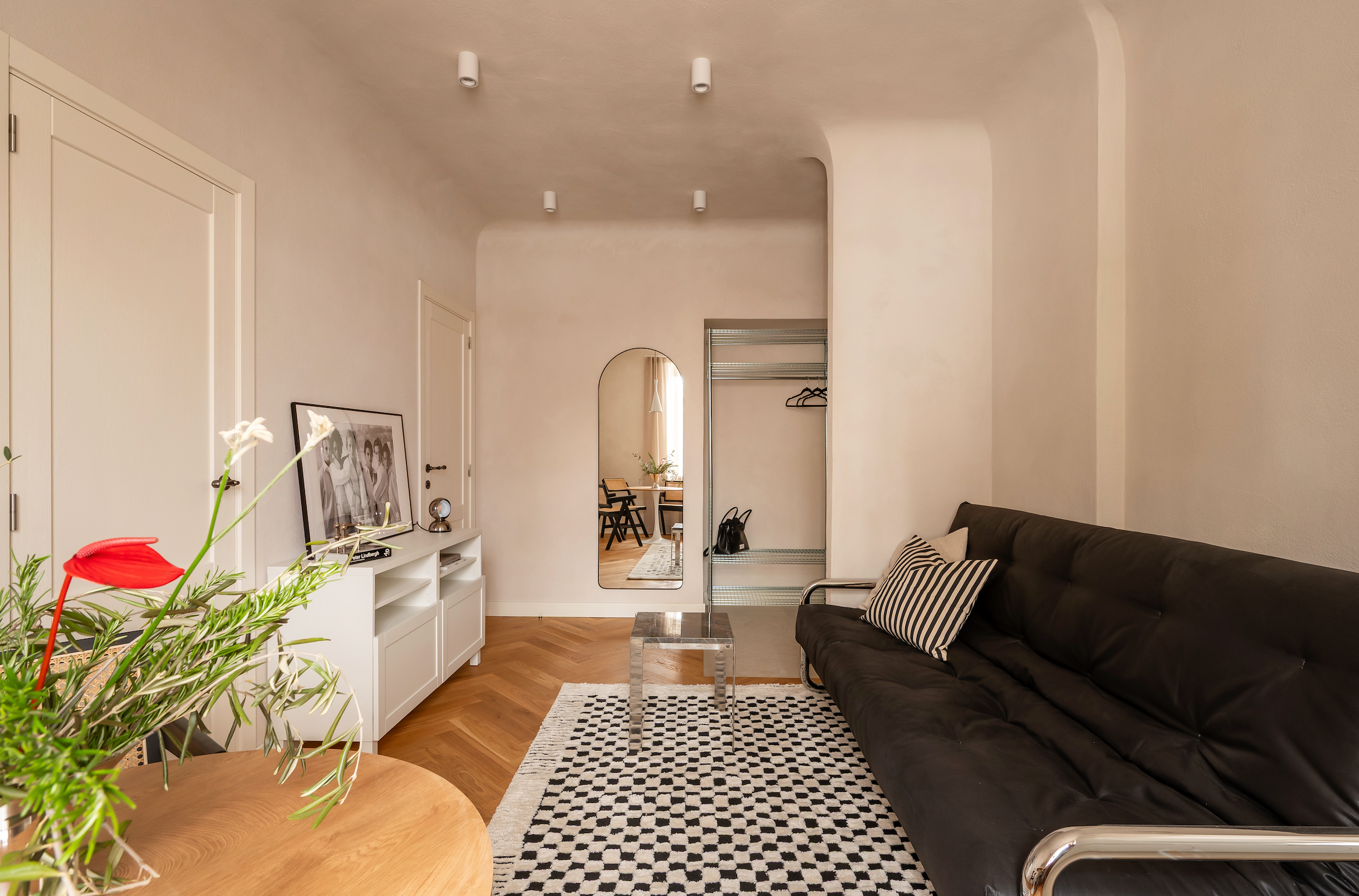 Modern living room with black sofa, wooden coffee table, and decorative elements. Walls painted with Kulta Limewash Paint.