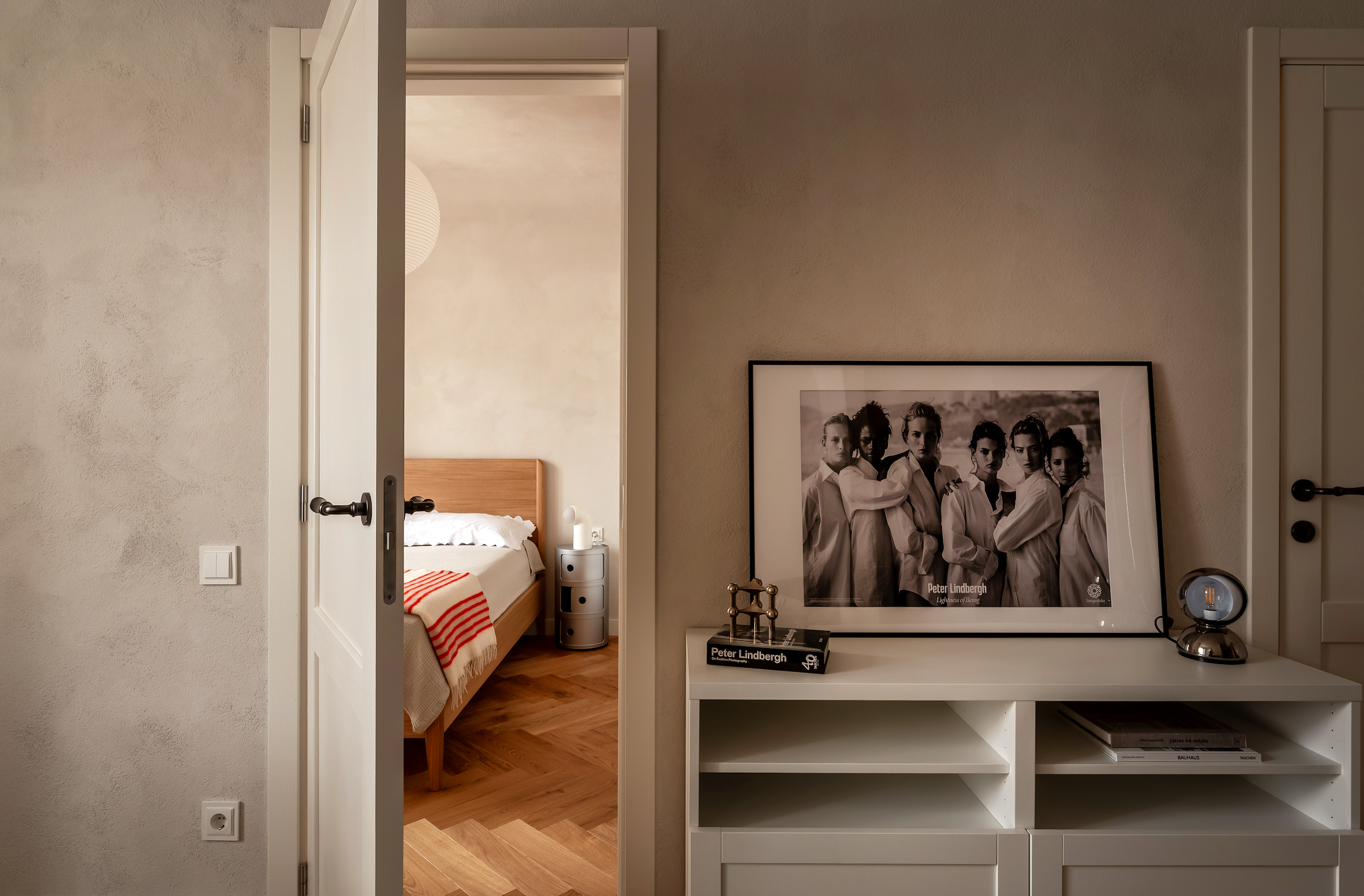 Room interior with a bed, wardrobe, and framed picture on the wall. Walls painted by Kulta Lime Paint.